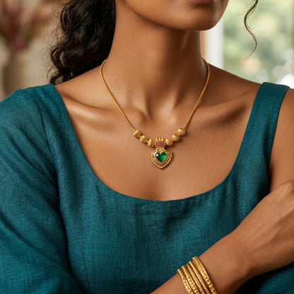 Woman wearing a gold plated palakka necklace and bangles with a blurred background