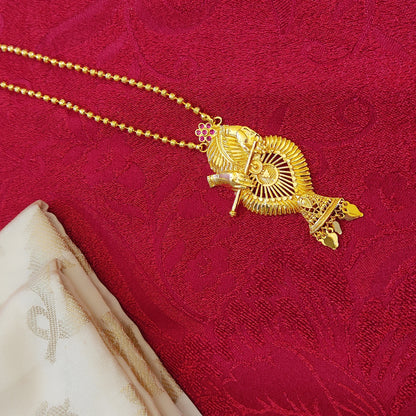 Gold plated necklace with a decorative Krishna with flute pendant on a red fabric background