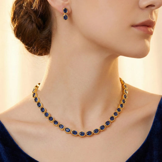 Close-up of a woman wearing a gold-plated necklace with blue stones and matching earrings.