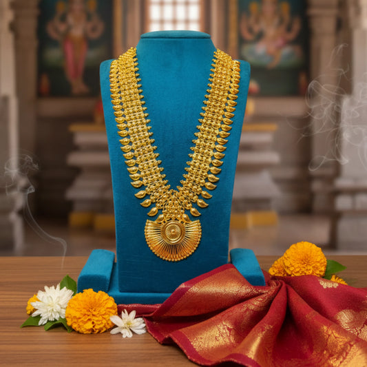 Gold plated long bridal haram necklace on a blue stand with flowers and fabric in a temple setting