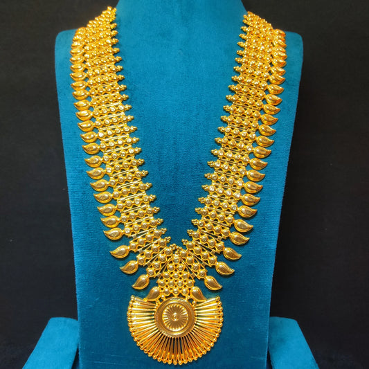 Gold plated long haram necklace on a blue stand against a black background
