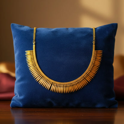 Gold plated necklace on a blue pillow with a blurred background