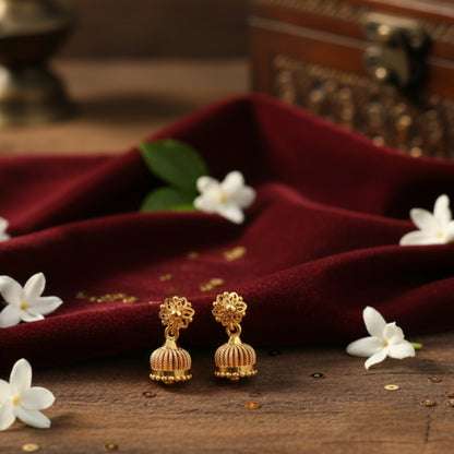 Gold plated Jimikki earrings on a dark red fabric with white flowers