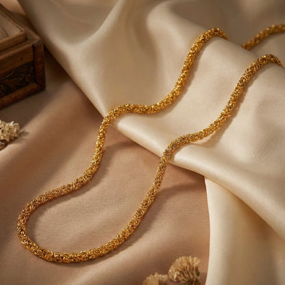Gold plated neckchain on a beige fabric background