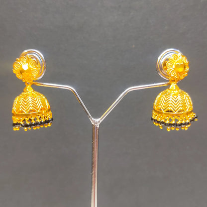 Gold plated traditional Jimikki/Jhumka with black beads earrings on a gray background