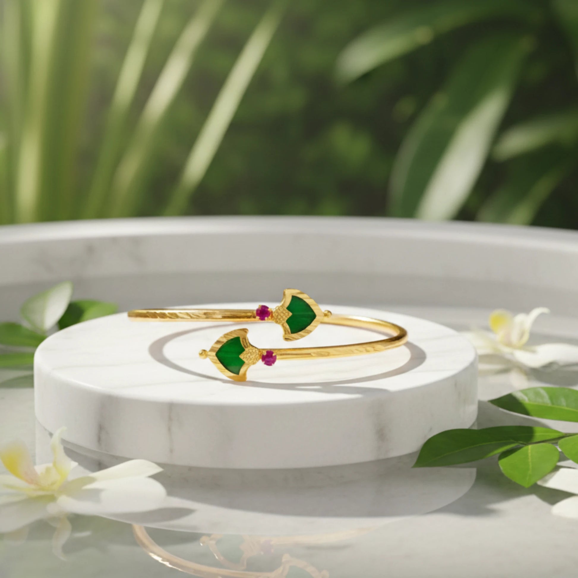 Gold plated Cuff/Torque/bracelet with green palakka and red stones on a white marble stand with a natural background