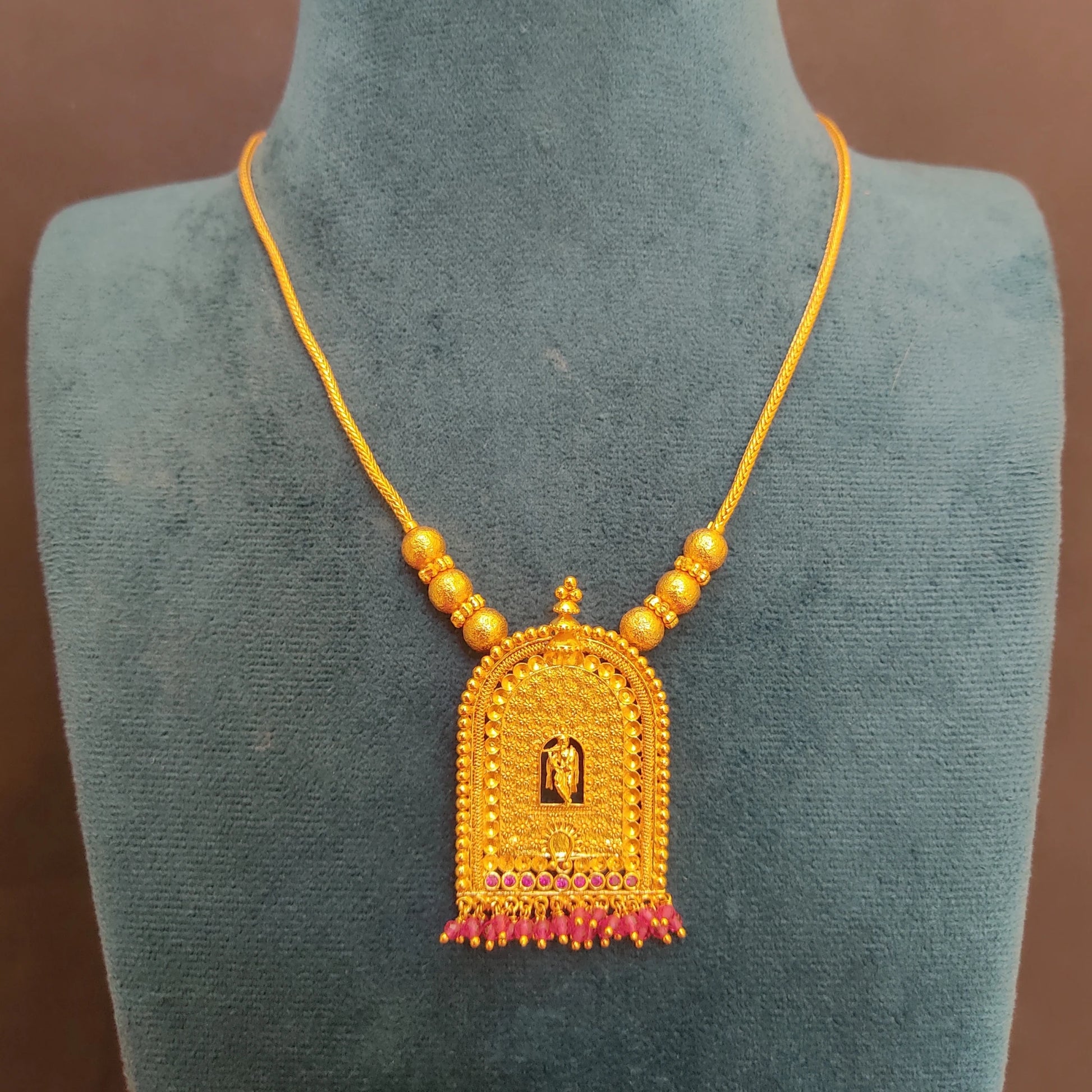 Gold Plated Traditional Krishna Temple Arch necklace with a pendant on a green mannequin
