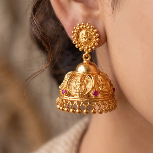 Gold plated Traditional Lakshmi Temple Jimikki/Jhumka earrings with intricate designs worn by a person