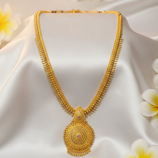 Gold plated long haram necklace with a mandala pendant on a mannequin with a soft white background