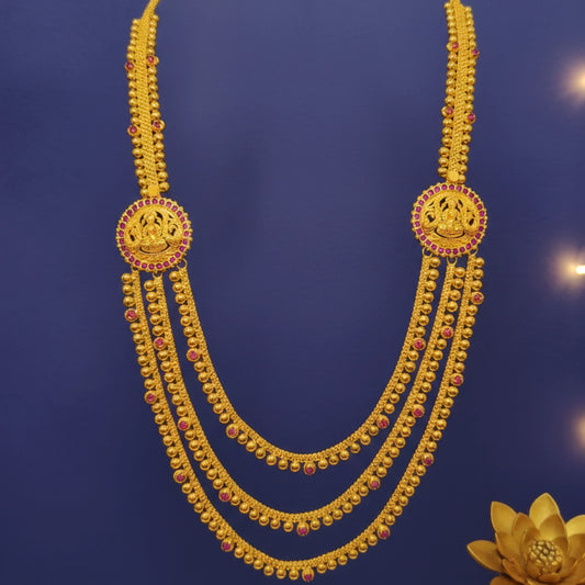 Gold plated necklace with red stones on a blue background
