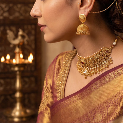 Woman wearing gold plated Traditional Classic Bell Jimikki/Jhumka with a blurred background