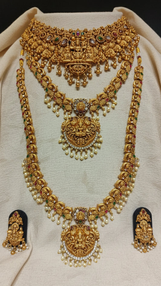  A Set of Antique Gold Finish Necklaces and choker with matching earrings with a blurred background