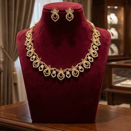 Gold toned necklace and earrings on a red velvet mannequin bust.