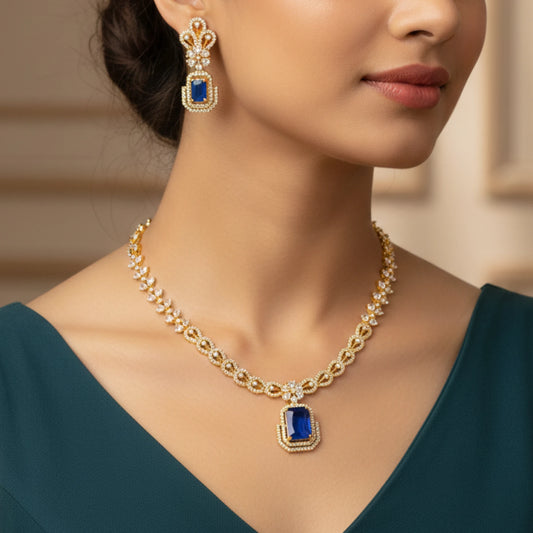 Woman wearing a gold-plated necklace and earrings with blue and white AD stones.