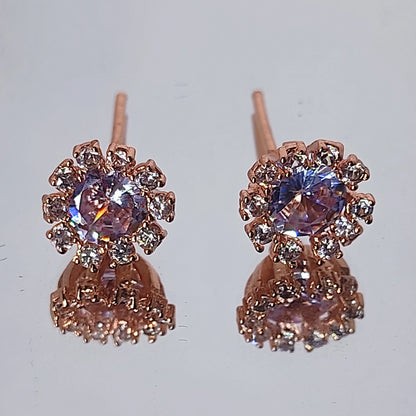 Rose Gold Plated Dainty Lavender Hue Earrings in AD stones on a reflective surface