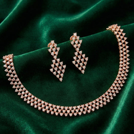 Rose gold necklace and earrings on a green velvet background