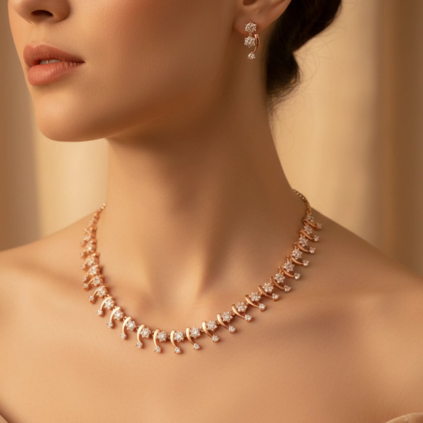 Close-up of a woman wearing a Rose Gold AD necklace and earrings against a warm beige background