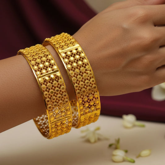 Gold plated Jali work bangles on a wrist with a blurred background