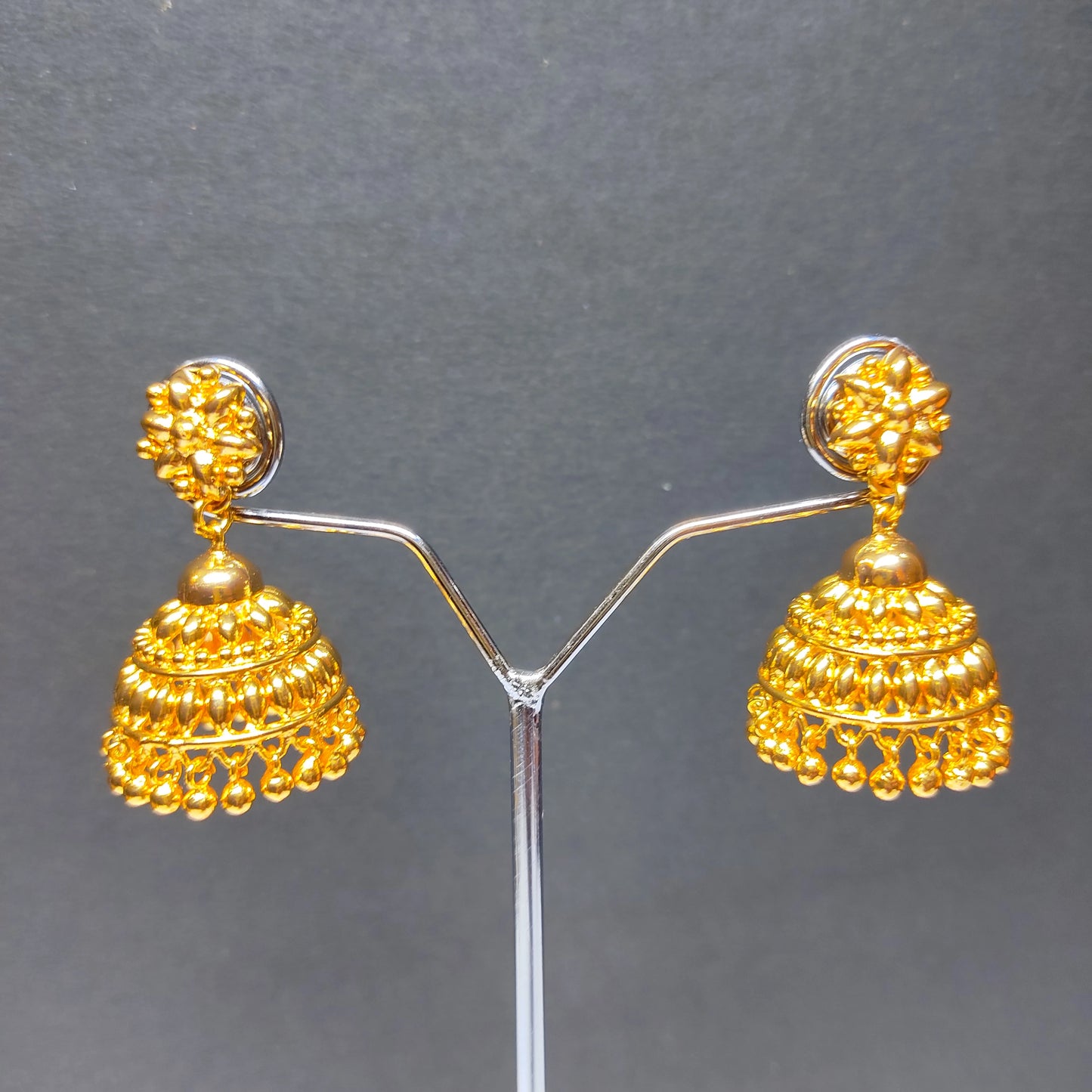 Pair of gold-plated earrings on a grey background