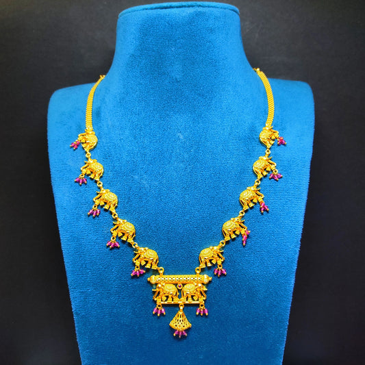 Gold plated necklace with elephant designs on a blue velvet stand against a black background
