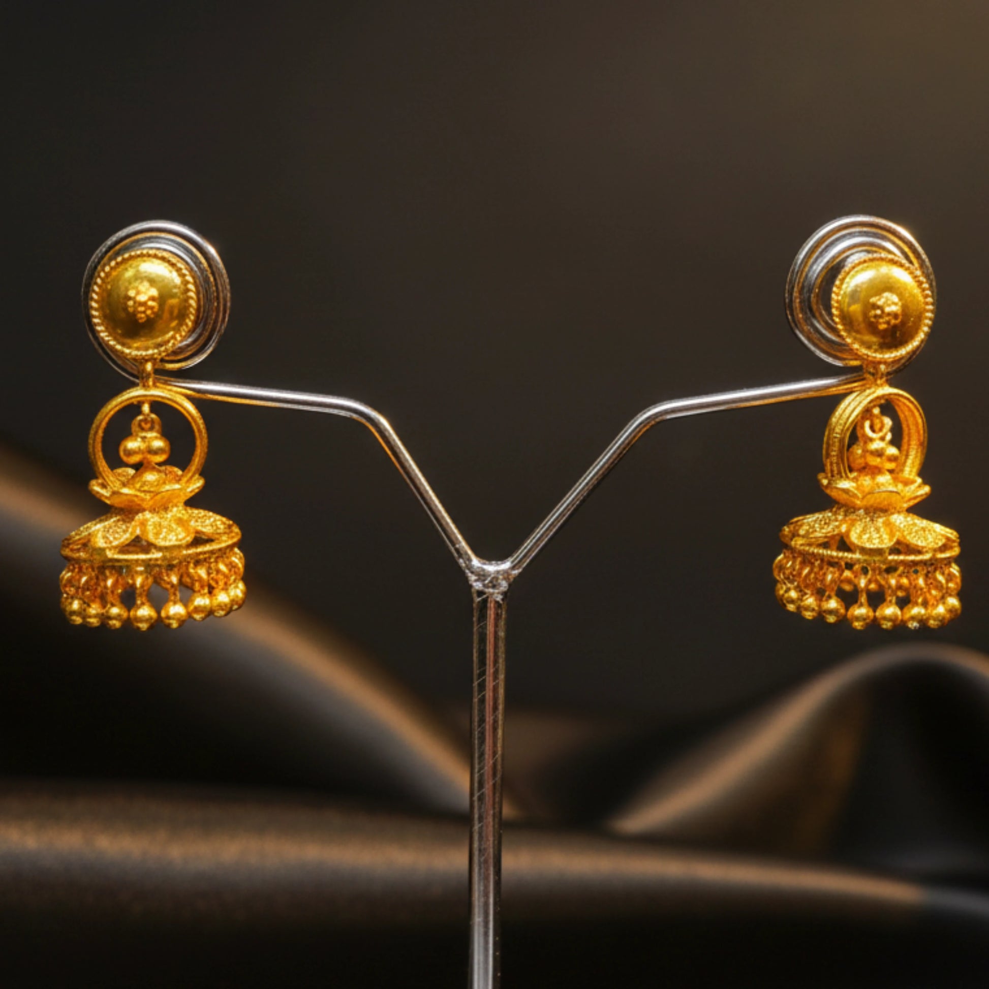 Gold plated earrings on a dark background