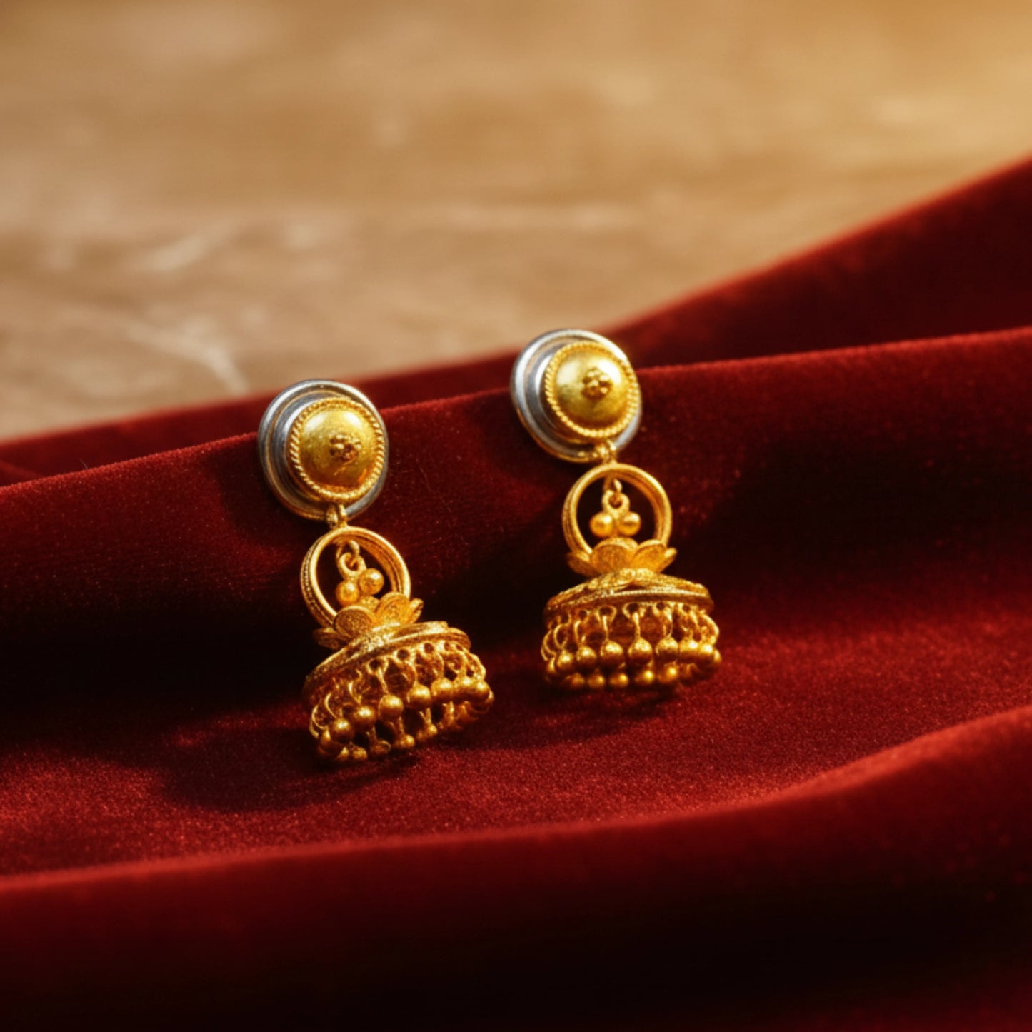 Gold plated earrings on a red fabric background