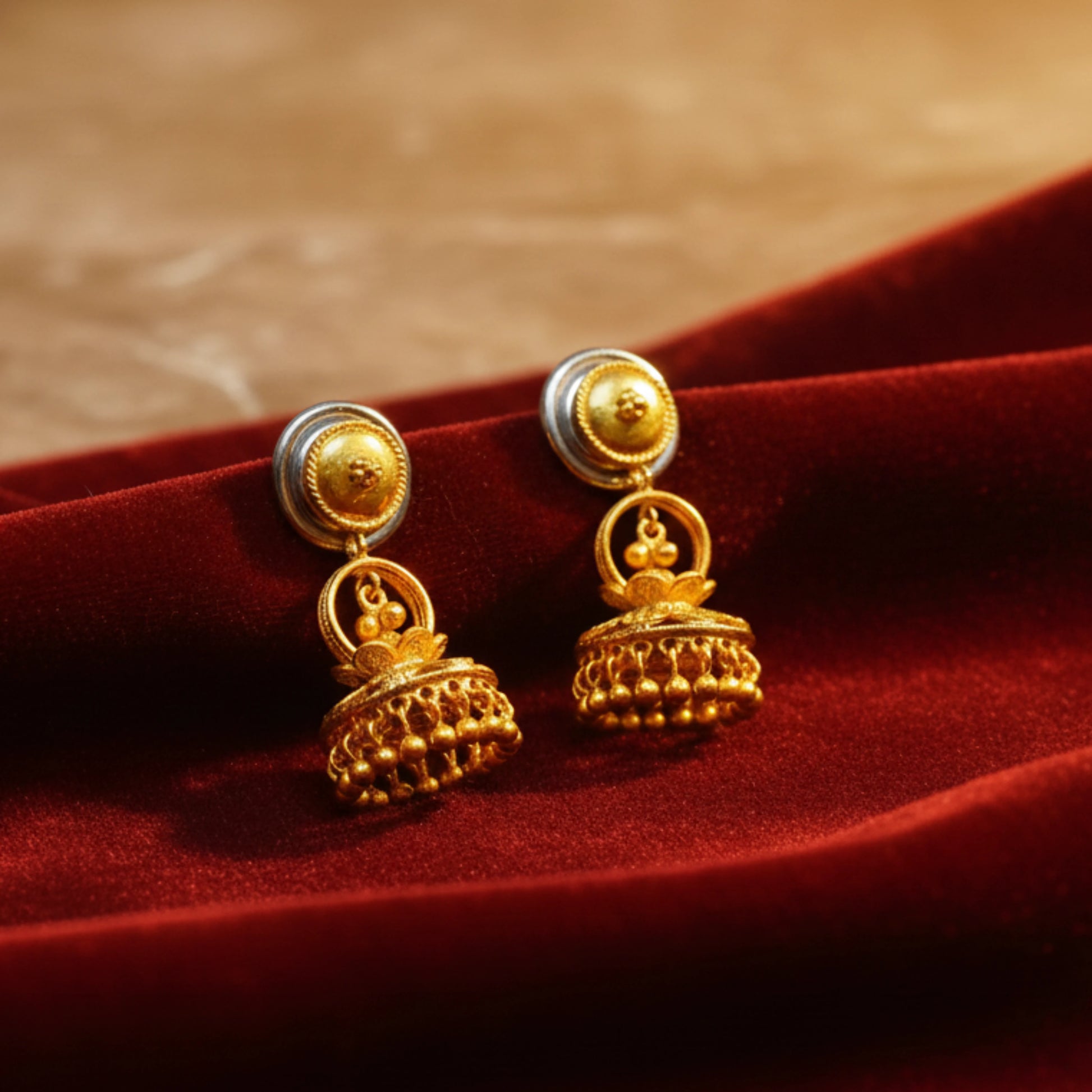 Gold plated earrings on a red fabric background