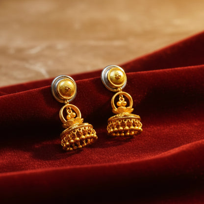 Gold plated earrings on a red fabric background