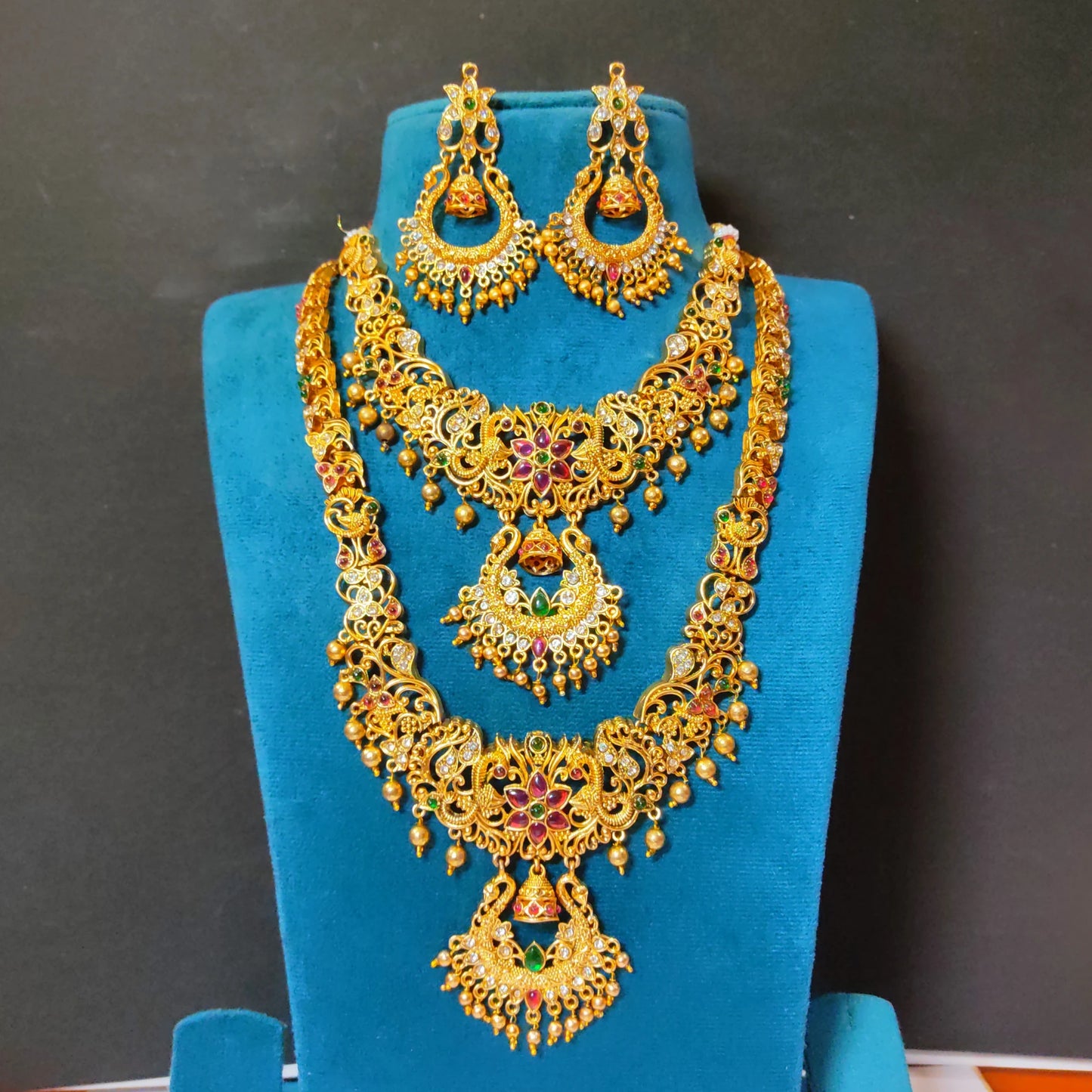 A rare collector's bridal set featuring an exquisite, intricately carved Chandbali (crescent) motif rarely seen in traditional South Indian matte temple jewelry layout configurations. Comes with a long haram, a short haram or choker and complimented with a chandbali earrings set