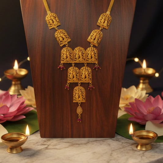 Gold plated Vrindavan heritage Radha Krishna necklace on a wooden stand with pink lotus flowers and candles in the background