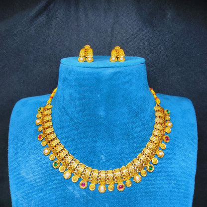 Antique Gold Finish necklace and earrings set on a blue velvet stand against a dark background