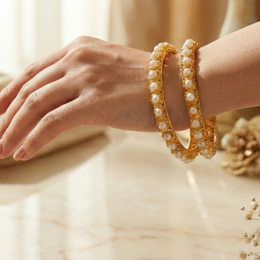 Gold plated with pearls Bangles on a hand with a soft background