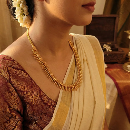 Woman wearing a gold-plated necklace with a traditional outfit
