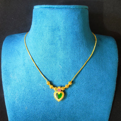Gold plated necklace with a heart-shaped pendant on a blue mannequin