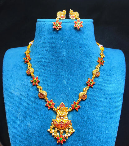 Gold toned necklace with floral designs on a blue stand