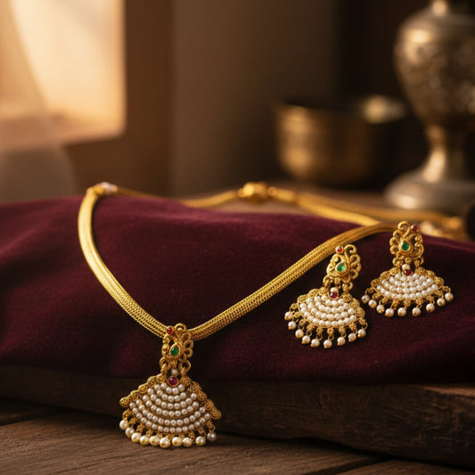 Antique Gold finish necklace with chandbali pendant and matching earrings on a purple cushion
