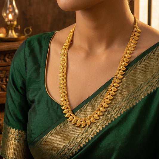 Green saree with gold border worn by a person, focusing on the gold plated necklace