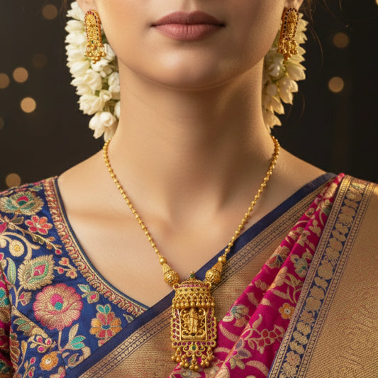 Woman wearing antique gold toned jewelry which has Radha Krishna pendant with a dark background