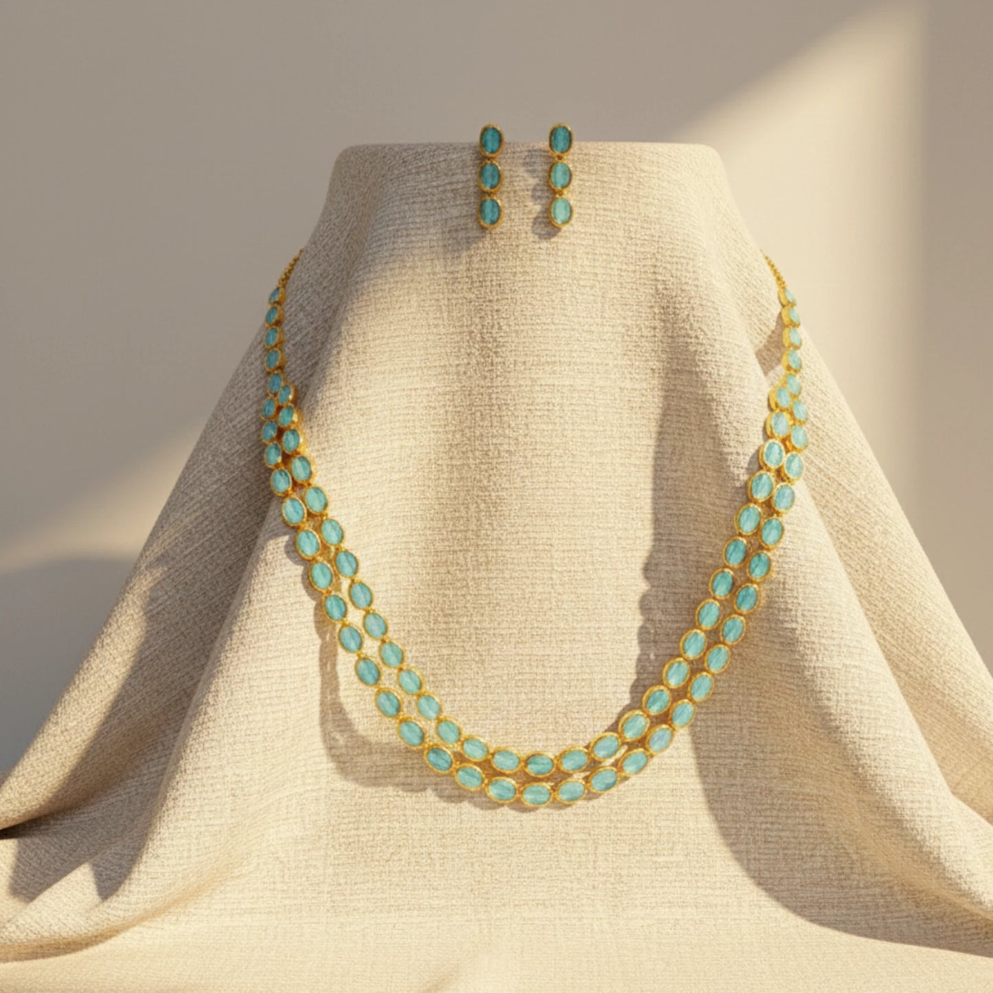 Turquoise Gold Plated necklace and earrings on a beige mannequin against a neutral background